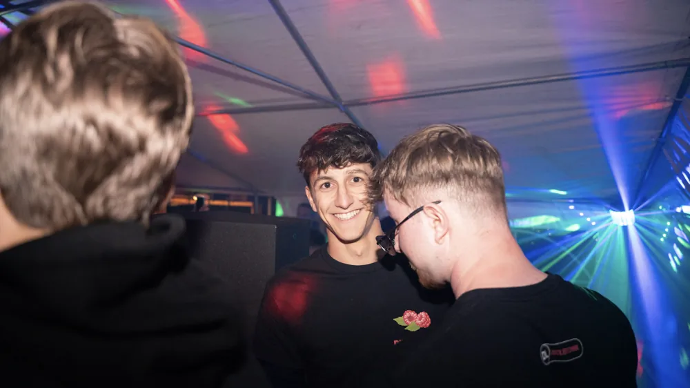 Freunde vor der Kamera zwischen den bunten Partylichtern